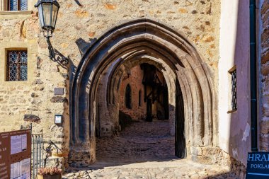 Güneşli tarihi kalede ortaçağ taş kemer girişi. 18 Mart 2025, Madalyon, Çek Cumhuriyeti.