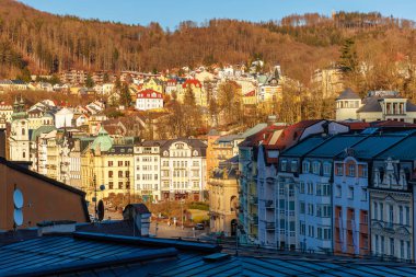 Karlovy 'nin sonbaharda çeşitli mimari ve orman tepelerinin manzarası. 18 Mart 2025, Karlovy Vary, Çek Cumhuriyeti.