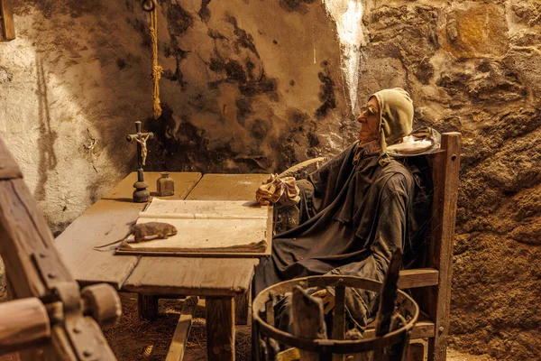 Ortaçağ keşişi loş bir taş odada kalem ve el yazması ile yazıyor. 18 Mart 2025, Madalyon, Çek Cumhuriyeti.