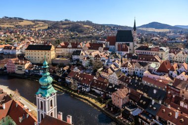 Nehir ve kilise kulesi olan tarihi Avrupa kasabasının manzarası. 20 Mart 2025, Cesky Krumlov, Çek.