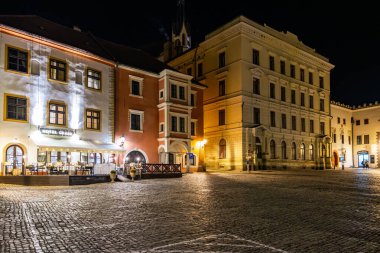 Yanan binalarla dolu tarihi kasaba meydanının gece manzarası. 20 Mart 2025, Cesky Krumlov, Çek.