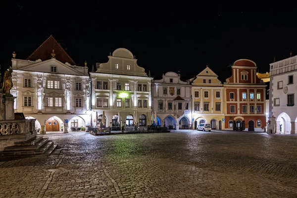 Geceleyin aydınlatılmış ortaçağ mimarisi ile tarihi kasaba meydanı. 20 Mart 2025, Cesky Krumlov, Çek.