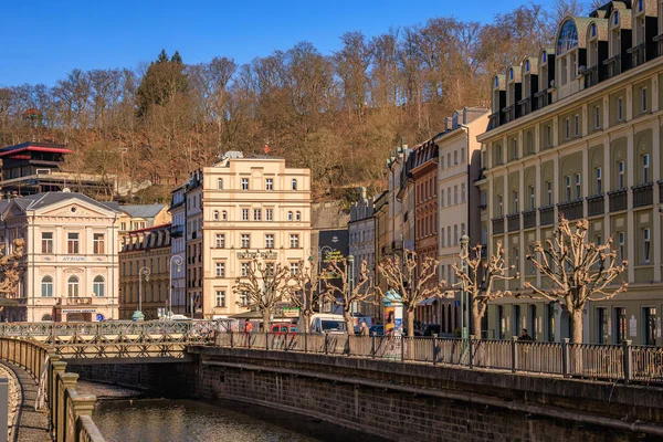 Karlovy 'deki resimli nehir kenarı mimarisi güneşli bir günde çeşitlilik gösterir. 19 Mart 2025, Karlovy Vary, Çek Cumhuriyeti.