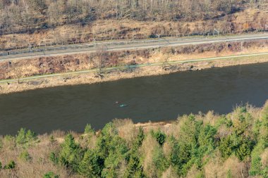 Baharın erken saatlerinde, açık bir günde kanolarla orman ve nehir manzarası..
