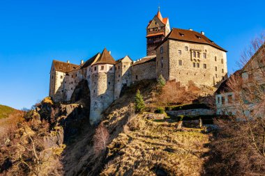 Muhteşem ortaçağ kalesi açık mavi gökyüzünün altındaki kayalık tepeye tünemişti..