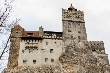 Drakula Kalesi 'nin tepesinde bir kulesi olan büyük bir bina. 16 Aralık 2024 Bran Romanya.
