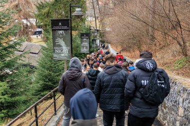 Bir grup insan Drakula Kalesi 'ndeki tepeden aşağı doğru yürüyorlar. 16 Aralık 2024 Bran Romanya.
