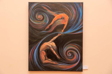 Havada bir kişinin diğerini tuttuğu iki kişinin resmi. Resim siyah ve turuncu renktedir. 12 Mart 2024 Balti Moldova