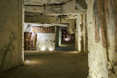 Yeraltı mağarasının girişi, kırsal dekorlu ve loş ışıklandırmalı. 6 Nisan 2025 Branesti, Moldova.