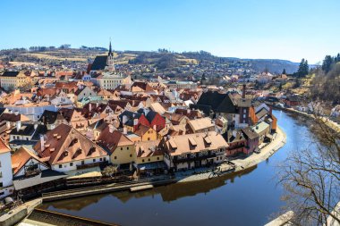 Cesky Krumlov 'un tarihi binaları ve açık mavi gökyüzünün altındaki Vltava nehri manzarası. 20 Mart 2025, Cesky Krumlov, Çek.