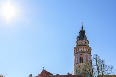 Açık mavi gökyüzüne karşı Cesky Krumlov kale kulesinde güneşli bir gün. 20 Mart 2025, Cesky Krumlov, Çek.