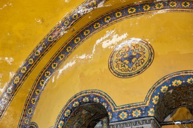 Tarihi sarı kemerli tavanda karmaşık geometrik desenler.