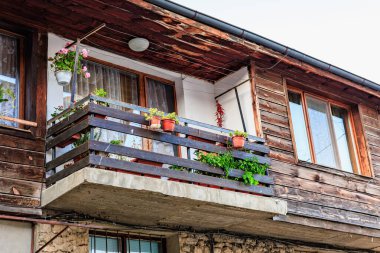 Balkonu ve saksısı olan ahşap bir ev..