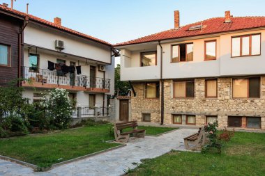 Gün batımında taş ve tuğladan evler olan rahat bir avlu. 1 Ağustos 2025, Nessebar Bulgaristan.