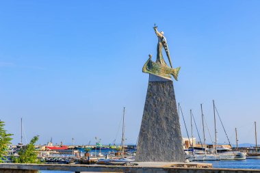 Deniz kenarındaki yat limanında açık mavi gökyüzüne karşı antik denizcilerin anıtı. 1 Ağustos 2025, Nessebar Bulgaristan.