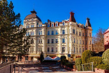 Açık mavi gökyüzü altında karmaşık mimarisi olan tarihi Avrupa binası. 18 Mart 2025, Karlovy Vary, Çek Cumhuriyeti.