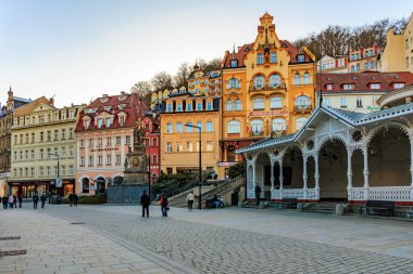 Renkli mimari ve Karlovy şehir meydanındaki insanlar. 18 Mart 2025, Karlovy Vary, Çek Cumhuriyeti.