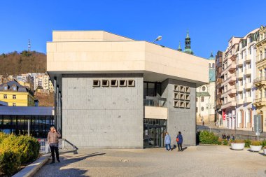 Açık bir günde şehir ortamında insanların bulunduğu modern mimari müzesi. 18 Mart 2025, Karlovy Vary, Çek Cumhuriyeti.
