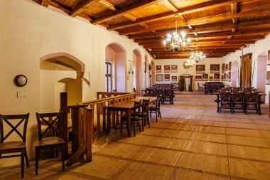 Tarihi binada ahşap tavanı ve avizeleri olan taşralı yemek salonu. 18 Mart 2025, Madalyon, Çek Cumhuriyeti.