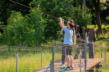 Genç beyaz erkekler yemyeşil parkta zeplin macerası kuruyor. 7 Haziran 2025 Hincesti Moldova.