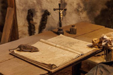 Köy ortamında açık kitap, fare ve çapraz çizgili klasik masa. 18 Mart 2025, Madalyon, Çek Cumhuriyeti.