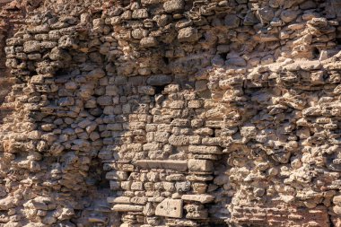 Kaba ve yıpranmış yüzeyi olan antik taş duvar dokusu.