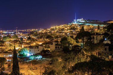 Kus adasi 'nin gece manzarası kıyı manzaralı şehir manzarasını aydınlatıyor. 3 Ağustos 2025, Ayvalik, Türkiye.