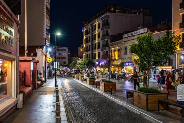 İzmir 'in hareketli bir caddesinde canlı kalabalık ve aydınlık binalarla dolu bir gece hayatı. 2 Ağustos 2025, Canakkale Türkiye.