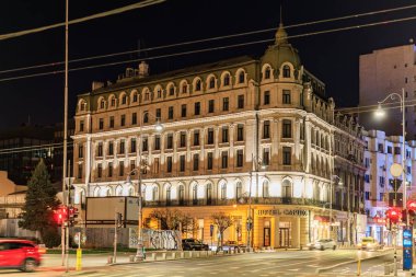 Şehir ortamında gece vakti tarihi bir otel binası aydınlandı. 8 Mart 2025 Bükreş Romanya.