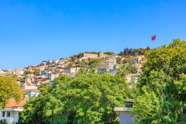 İzmir 'in renkli şehir manzarası. Türk bayrağı ve antik kale tepesi. Otantik arkaplan.