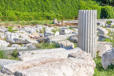 Fazla büyümüş yeşilliğin ortasında flütlü mermer sütunlu antik kalıntılar. İzmir, İzmir 'de antik İzmir kalıntıları.