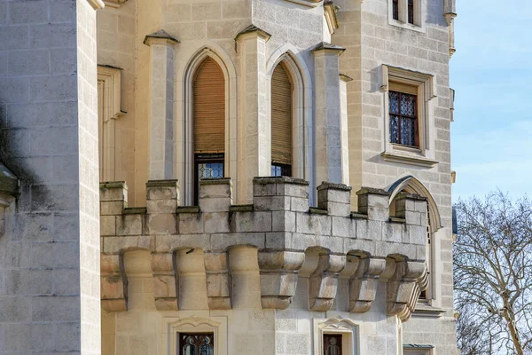 Kemerli pencereleri ve balkonları olan taş kalenin gotik mimarisi..