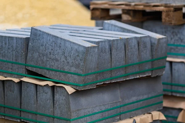 Sağlam beton bloklar bir inşaat alanında düzgünce düzenlenir. İşçiler gün ışığında açık gökyüzü altında yaklaşan inşaat görevlerine hazırlanıyorlar.