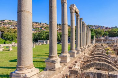 İzmir 'deki antik Roma harabeleri. Açık mavi gökyüzünün altında taş sütunlar var. 4 Ağustos 2025, İzmir Türkiye.
