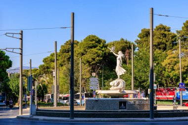 Çevresi doğa ve kentsel unsurlarla çevrili akışkan bir kadın heykeli. 4 Ağustos 2025 İzmir Türkiye.