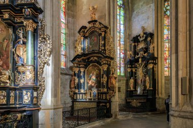 Tarihi barok kilisesinin içinde süslü sunaklar ve vitraylı pencereler 22 Mart 2025, Kutna Hora, Çek Cumhuriyeti.