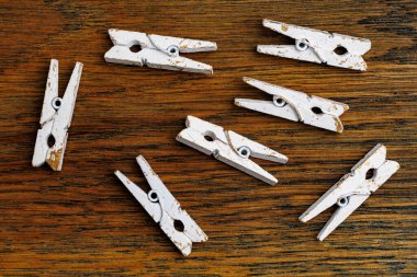 Bir grup beyaz mandal tahta bir yüzey üzerinde duruyor..