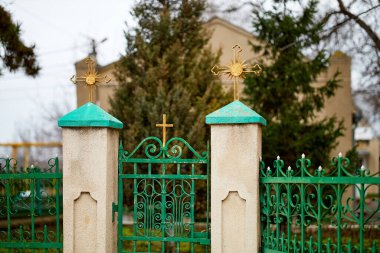 Üzerinde iki haç olan yeşil bir kapı. Kapı bir binanın önünde, kapalı kilise kapısında.