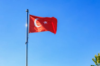Türk bayrağı açık mavi gökyüzüne doğru dalgalanıyor.