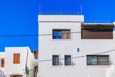 Açık mavi gökyüzünün altındaki modern beyaz yerleşim yeri.