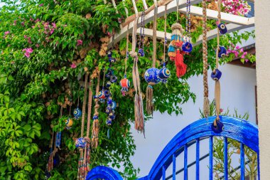 Dekoratif nazar büyüsü ve yemyeşil renkli mavi kapı. 5 Ağustos 2025, Bodrum Türkiye.