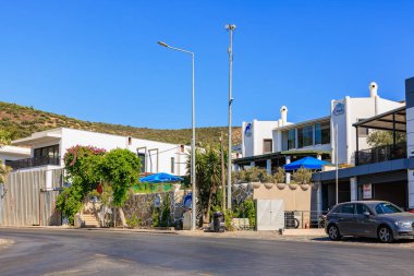 Modern beyaz binaları ve mavi şemsiyeleri olan büyüleyici Akdeniz caddesi. 5 Ağustos 2025, Bodrum Türkiye.