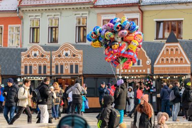 Bir grup insan elinde balonlarla caddede yürüyen bir adamla yürüyorlar. 14 Aralık 2024 Brasov Romanya