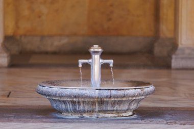 Zarif mermer koridorda çift ağızlı taştan bir çeşme..