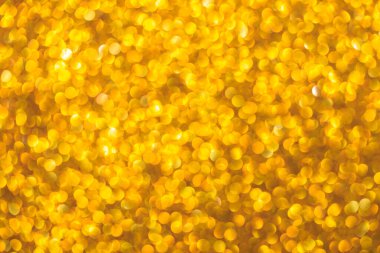 Bir sürü küçük daireleri olan altın bir arka plan. Çemberler bulanık ve örtüşüyor.