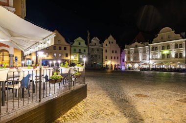 Geceleri tarihi kasaba meydanı aydınlık binalar ve Avrupa 'da rahat bir açık hava kafesi. 20 Mart 2025, Cesky Krumlov, Çek.