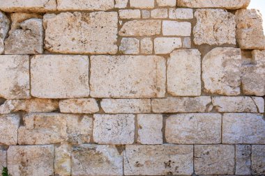 Antik yıpranmış taş duvar, büyük bloklar ve açık havada eşsiz bir doku. İzmir, İzmir 'de antik İzmir kalıntıları.