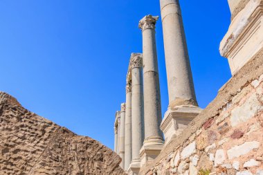 Tarihi harabelerde açık mavi gökyüzüne karşı antik Roma sütunları. İzmir, İzmir 'de antik İzmir kalıntıları.