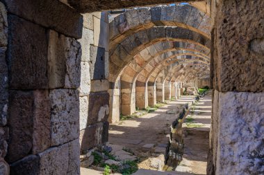 Antik Roma su kemerleri güneş ışığıyla aydınlatılmış harabelerde taş işçiliğiyle detaylandırılmış. İzmir, İzmir 'de antik İzmir kalıntıları.