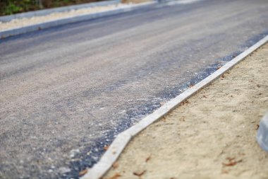 Beton sınırları olan yeni asfalt yol.